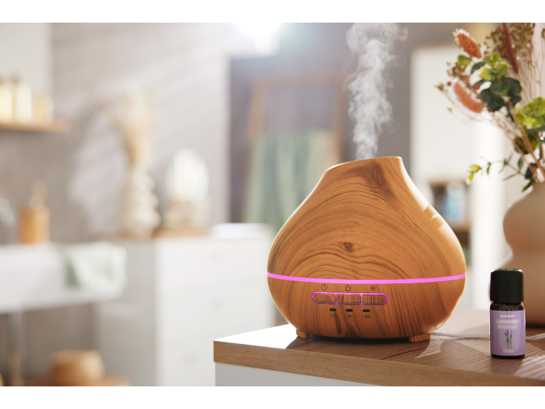 Diffusore di aromi in legno con illuminazione e boccetta di olio essenziale di lavanda.