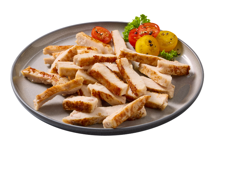 Piatto con striscioline di petto di pollo grigliato, pomodorini e foglie di lattuga.