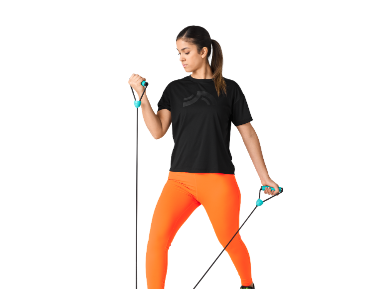 Donna in maglietta nera e leggings arancioni che si allena con una fascia di resistenza.