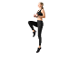 Donna in top sportivo e leggings neri, che si allena.