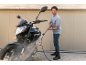 Uomo che pulisce una moto con un'idropulitrice