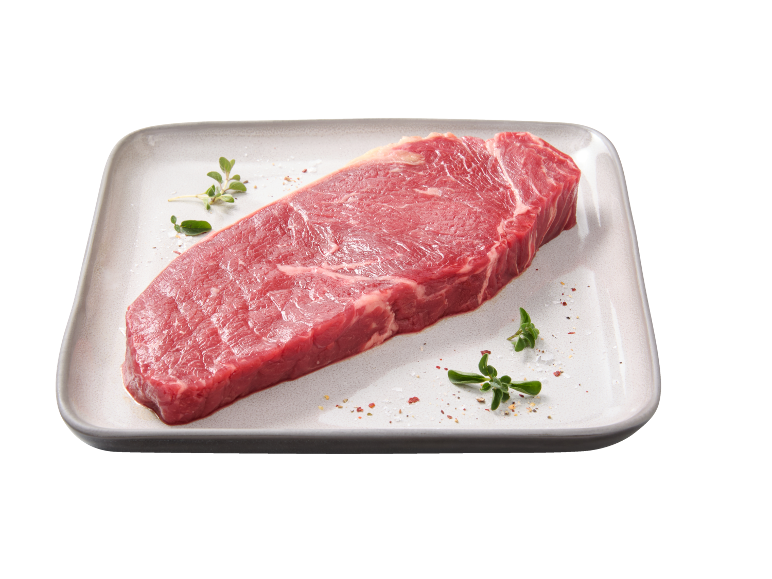 Bistecca di manzo cruda con erbe e spezie su un piatto rettangolare.