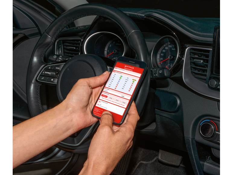 Una persona in auto tiene uno smartphone con un'applicazione di diagnostica auto.