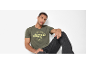 Uomo in t-shirt verde oliva con stampa 'AUTHENTIC DENIM ORIGINAL' e jeans scuri.