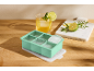 Vassoio per cubetti di ghiaccio in silicone verde menta con coperchio, bevanda e tagliere di marmo.