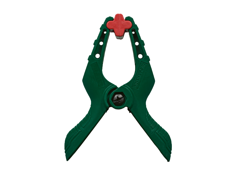 Morsetto a molla verde con ganasce rosse su sfondo nero.