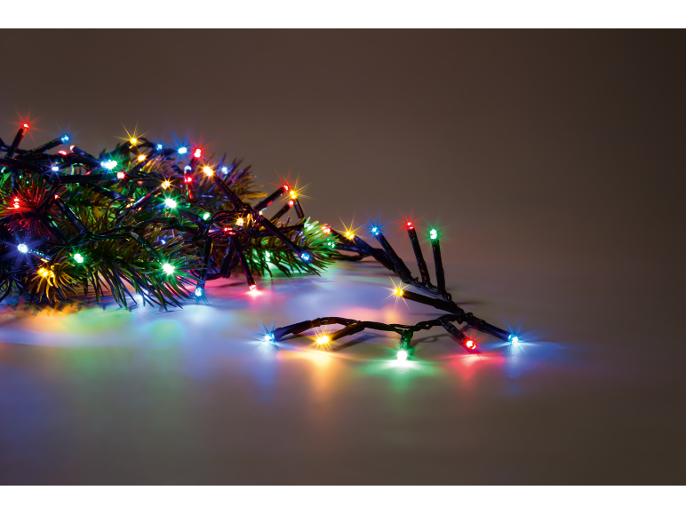 Luci di Natale LED multicolori con rami di abete, che creano un'atmosfera festosa.