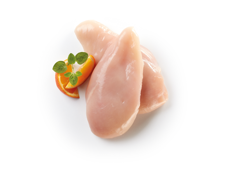 Petto di pollo crudo con una fetta d'arancia e erbe fresche.