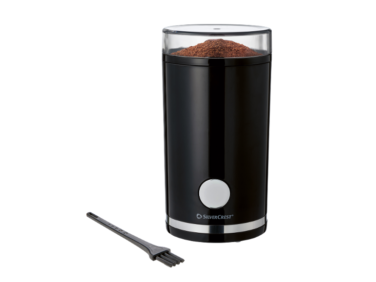 Macinacaffè nero con coperchio trasparente pieno di caffè macinato e una spazzola per la pulizia.