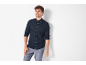 Uomo in camicia a maniche lunghe blu scuro e pantaloni grigio chiaro.