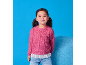 Bambina con maglione rosa a maglia e jeans, sorridente su sfondo blu.