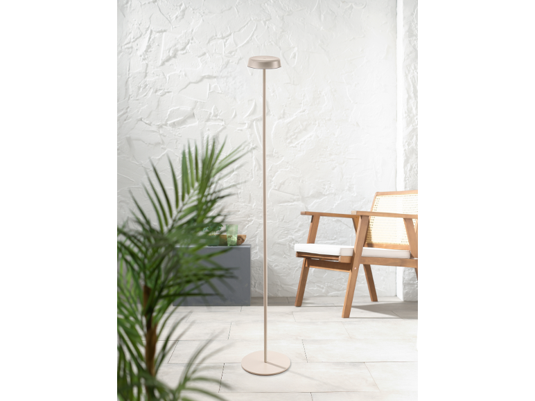 Lampada da terra beige su una terrazza con sedia in legno e pianta.
