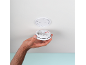 Una mano tiene un rilevatore di fumo, pronto per essere montato a soffitto.