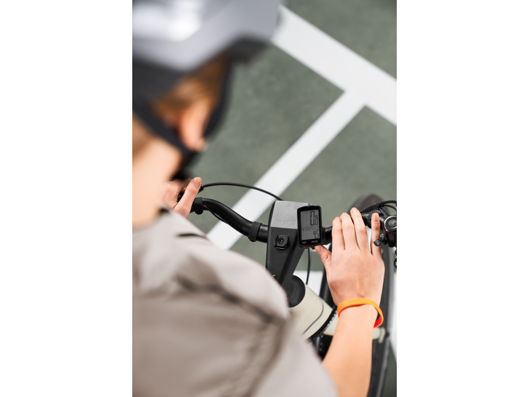 Persona in bicicletta che guarda un ciclocomputer con letture di velocità di 0.0 e 4.5.