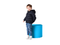 Bambino sorridente in piumino blu scuro, jeans e scarpe da ginnastica bianche.