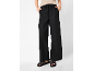 Pantaloni neri ampi con coulisse e sandali intrecciati.