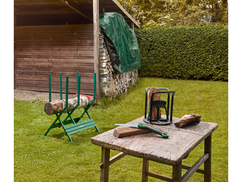 Cavalletto per segare e spaccalegna in un giardino, con sega e legno su un tavolo.