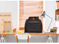 Borsa nera per macchina da cucire su una scrivania in legno con forniture artigianali.