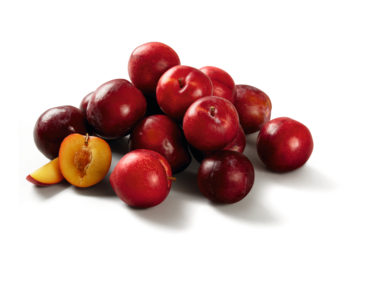 Mucchio di prugne rosse, con una tagliata a metà che rivela la polpa dorata.