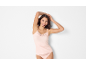 Donna sorridente in canotta e slip in pizzo rosa chiaro.