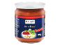 Vasetto di pesto rosso etichettato 'Pesto Rosso', circondato da basilico, anacardi e formaggio.