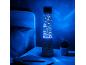 Lampada a torre blu con personaggi a tema, su un comodino accanto a un letto.