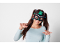 Ragazza sorridente con maschera da gatto nera e maglietta azzurra.