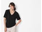 Donna con maglietta nera a maniche corte e pantaloni beige.