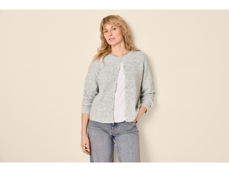 Donna con cardigan grigio, maglietta bianca e jeans blu.