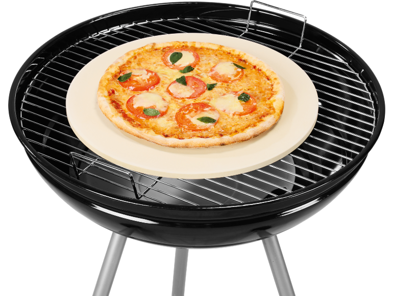 Pizza margherita su una pietra per pizza rotonda su un barbecue nero.