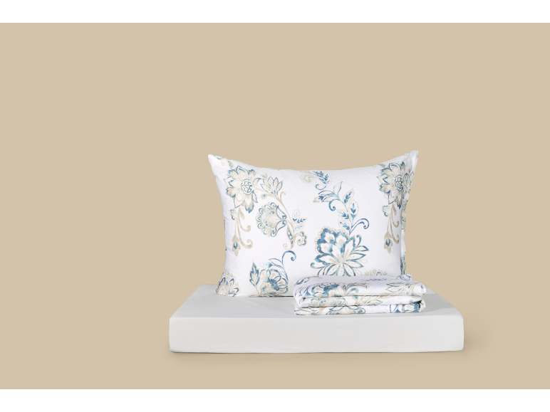 Set di biancheria da letto bianca con motivi floreali blu e beige, include un cuscino e lenzuola piegate.