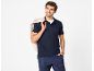 Uomo in polo e pantaloni blu scuro, con una giacca sulla spalla.