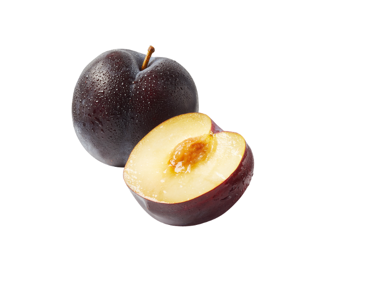 Prugna matura e mezza prugna con nocciolo su sfondo nero.