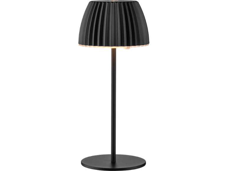 Lampada da tavolo nera con paralume plissettato e base rotonda, illuminata.
