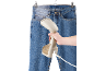 Vaporizzatore portatile per indumenti che stira un paio di jeans blu.