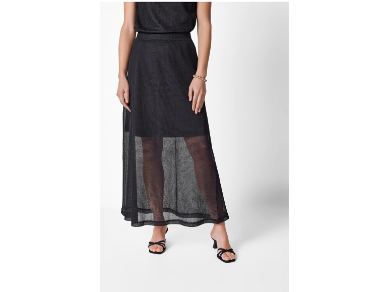 Donna con gonna lunga in rete nera e sandali neri con tacco.