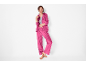 Donna in tuta fucsia, giacca con cerniera e pantaloni larghi.