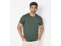 T-shirt verde scuro da uomo con scritta «Thrive in the unknown» e pantaloni beige.