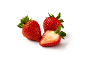Due fragole intere e una fragola tagliata a metà con foglie verdi su sfondo bianco.