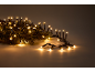 Luci di Natale calde e brillanti su un ramo di pino.