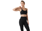 Donna in top sportivo nero a costine e leggings abbinati.