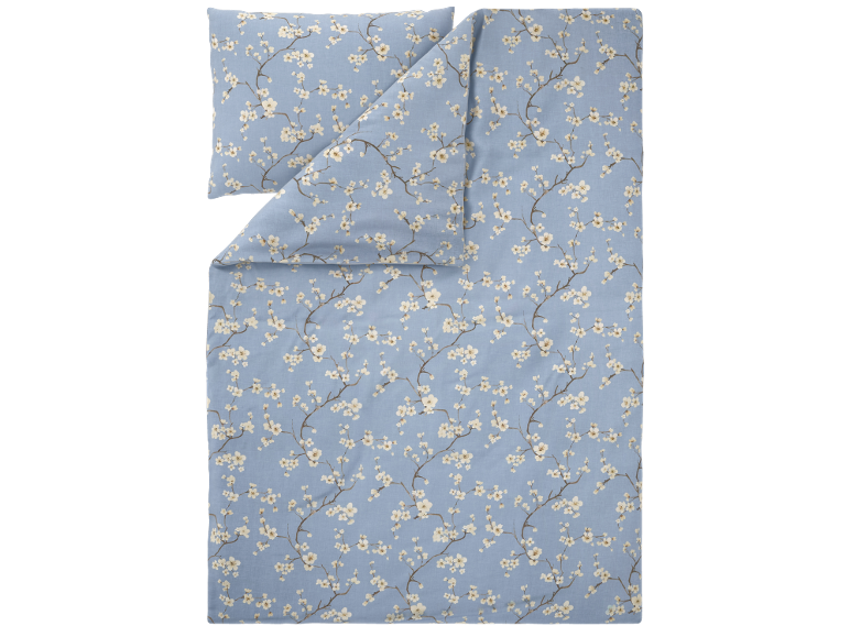 Completo letto azzurro con motivo di rami fioriti.