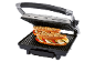 Piastra grill con due panini farciti con verdure e formaggio.