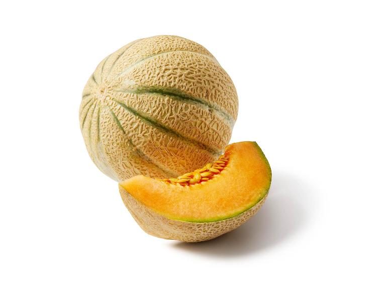Melone cantalupo intero e una fetta con semi su sfondo bianco.