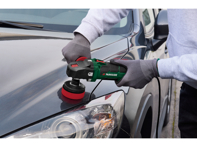 Persona che lucida un'auto grigio scuro con una lucidatrice elettrica.
