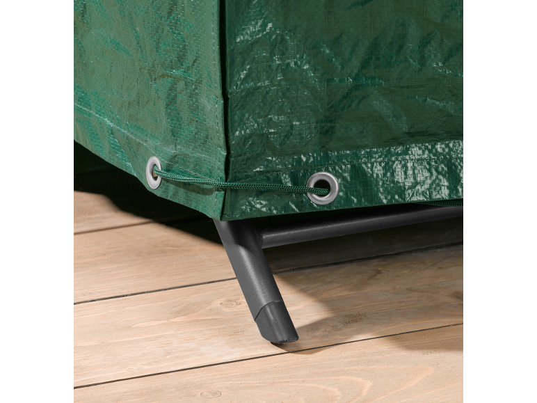 Telo di copertura verde con occhielli e coulisse, che copre i mobili su un pavimento in legno.