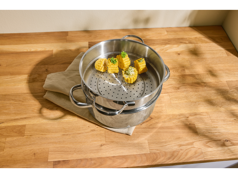 Mais in una vaporiera su un piano di lavoro in legno.