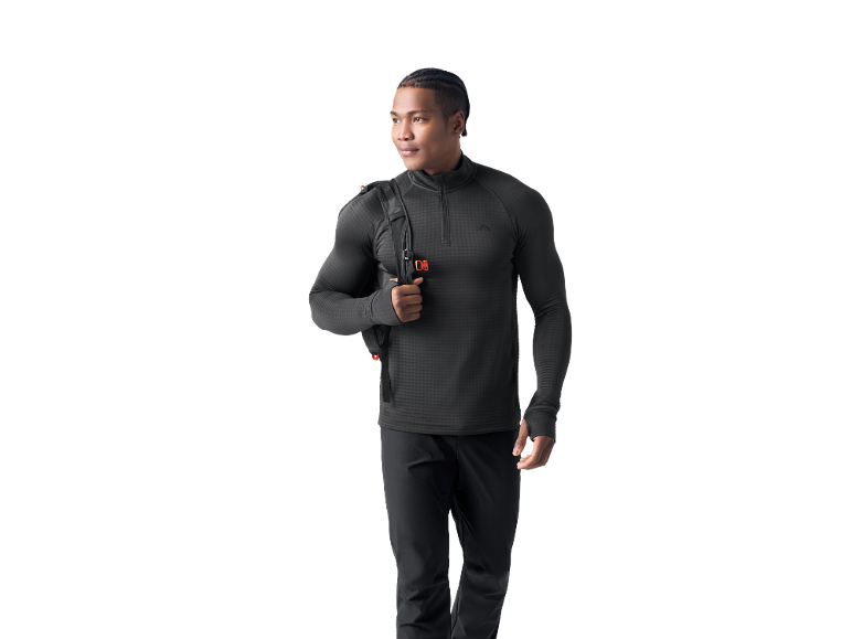 Uomo in top sportivo nero a maniche lunghe e pantaloni, con uno zaino.