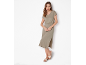 Donna in abito midi color kaki con vita elasticizzata e sandali piatti beige.