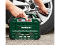 Uomo che gonfia un pneumatico d'auto con un compressore d'aria portatile verde.